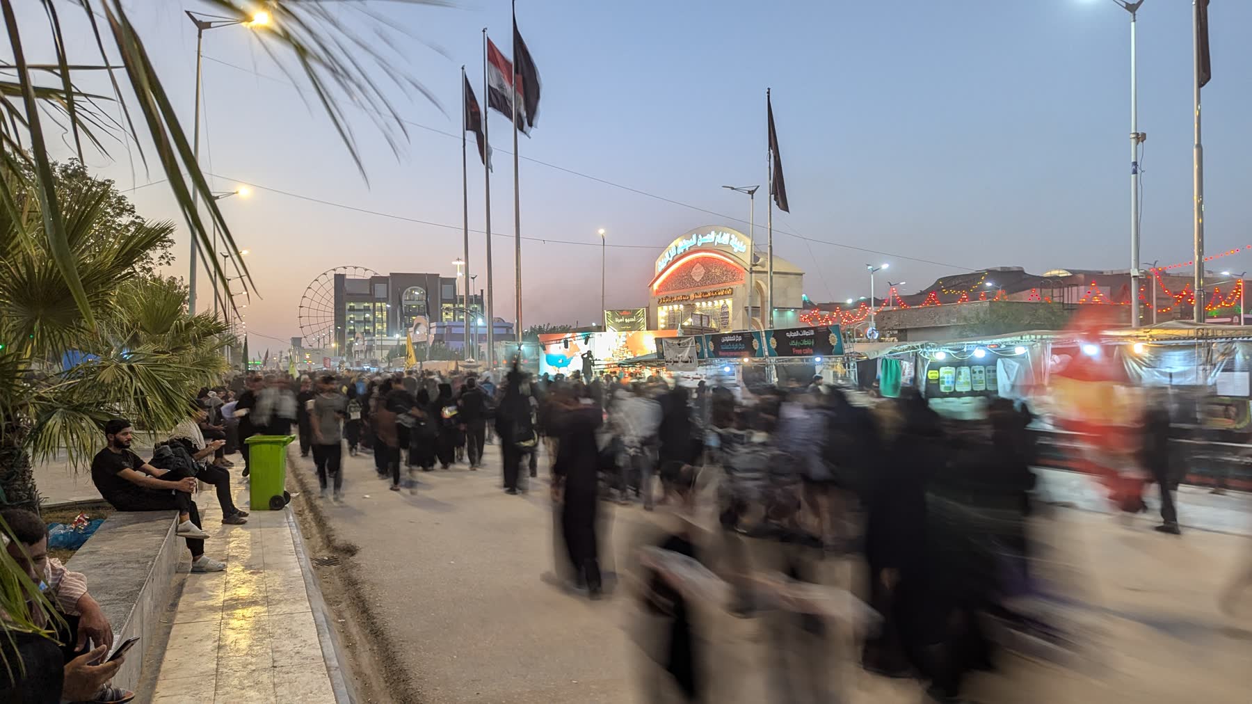 Pilgrims walking the Najaf to Karbala road at dusk during Arba'een
